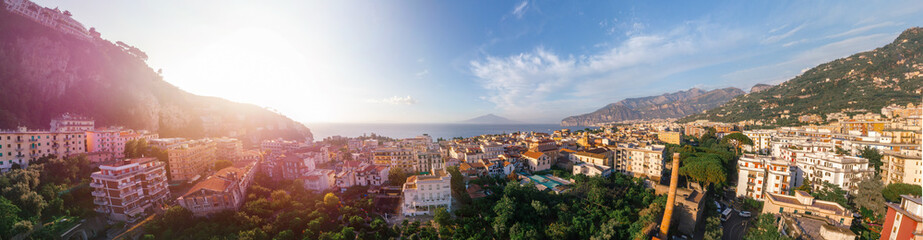 Fototapeta na wymiar Beautiful panoramic aerial view on the center of Sorrento city, sunset, houses and streets, sea views and a Vizuvius, Napoli in the distance. Travel and vacation concept on Italy. Infrastructure.
