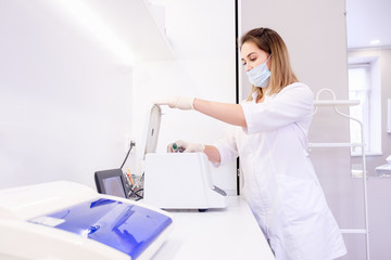 Charming young female scientist stacks analysis in a climate control chamber in a laboratory for...