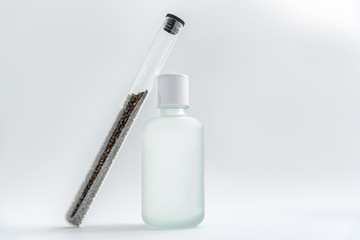 Babchi seeds in glass tube and cosmetics bottle, bakuchiol ingredient.