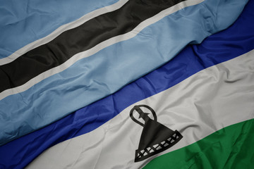 waving colorful flag of lesotho and national flag of botswana.