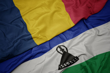 waving colorful flag of lesotho and national flag of chad.