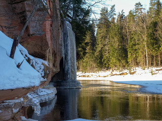 beautiful winter landscape with colorful iceberg, beautiful long icicles on the sandstone wall