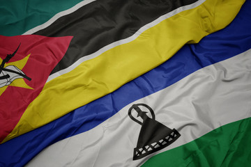waving colorful flag of lesotho and national flag of mozambique.
