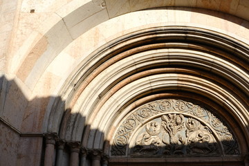 Marble portal of the baptistery of Parma. The building has an external façade built in pink Verona...