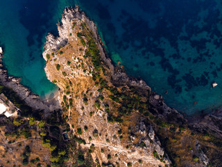 Fototapeta na wymiar Beautiful top down aerial view of wilderness bay and mountains on sunrise, hiking to a wild beach, tourist destination place for snorkeling and kayaking. Nerano, Massa Lubrense, Ieranto bay, Italy
