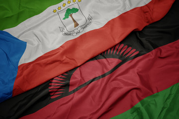 waving colorful flag of malawi and national flag of equatorial guinea.