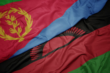 waving colorful flag of malawi and national flag of eritrea.