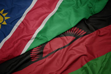 waving colorful flag of malawi and national flag of namibia.