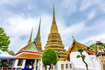 Fototapeta premium Wat Pho temple in Bangkok city, Thailand. View of pagoda and stupa in famous ancient temple. Religious buildings in buddhism style near Grand Palace. Oriental and Asian style, famous tourist target.