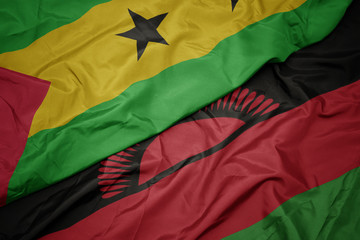 waving colorful flag of malawi and national flag of sao tome and principe .