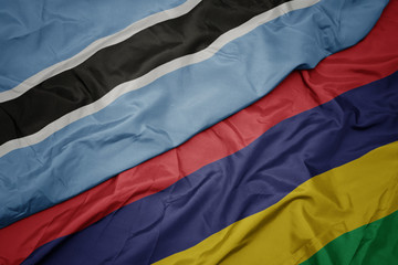 waving colorful flag of mauritius and national flag of botswana.