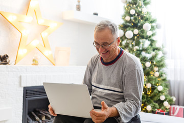 Smiling happy elderly man with laptop.