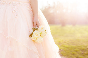 Beautiful Bride with bridal flowers in Weddingdress and amazing sun