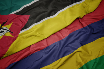 waving colorful flag of mauritius and national flag of mozambique.