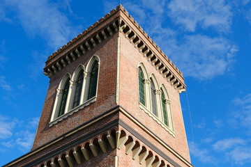 Obraz premium Neo-Gothic tower. Textile Museum in Busto Arsizio. Neo-Gothic construction in terracotta bricks with turrets and ogival windows.