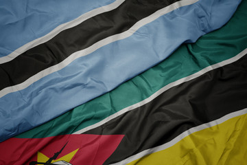 waving colorful flag of mozambique and national flag of botswana.