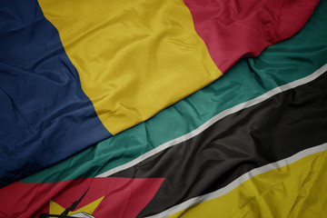 waving colorful flag of mozambique and national flag of chad.