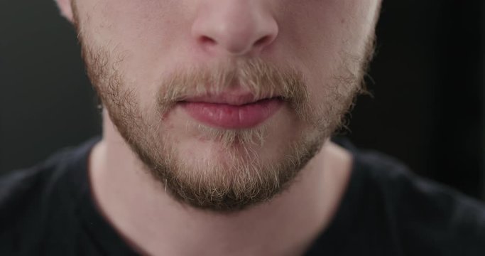 Slow motion closeup shot of bearded man swallows a pink pill and drinks it with water
