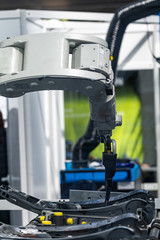 Robotic arm welding system in a manufacturing production plant