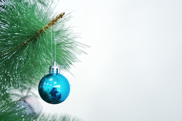  Decorative blue ball toy on Christmas green tree. Approach of new year 2020. Front view is close. Copy space. Soft selective focus.