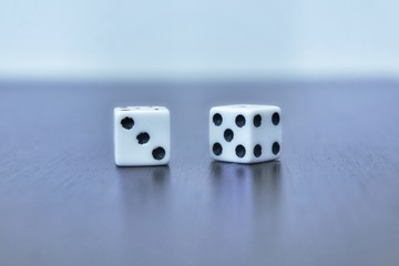  Two white dice - cubes on gray background. On one, three, on other five and four. Front view. Selective focus. Vignette