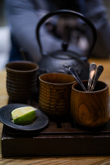 black Chinese clay clay teapot on the table, cups, spoons, lemon, lime, tea party, tea ceremony