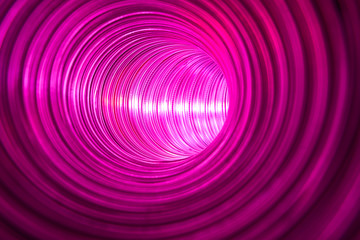 Imaginary passageway to optimistic world. Futuristic metallic circular tunnel illuminated by bright light source reflected in shiny walls.