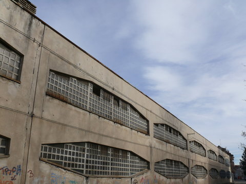 Industrial archeology buildings in the city of Busto Arsizio. Facade of an old factory with glass block windows.