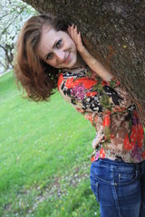 Red-haired girl walks among the Apple trees in the garden