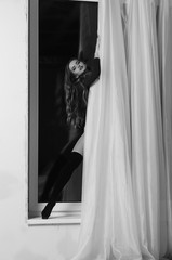 Sexy young woman with big breast. Girl posing on black wall in studio.