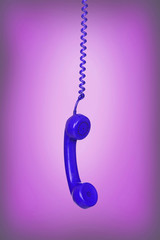 Blue vintage phone hanging of a cable