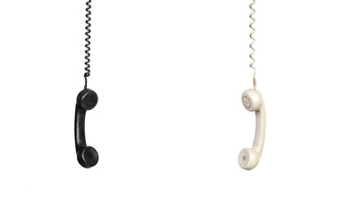 Two vintage phones hanging of a cable