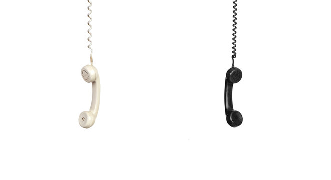 Two vintage phones hanging of a cable