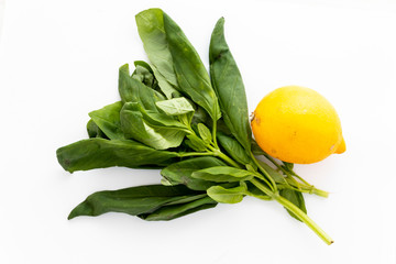 A handful of fresh green basil and a yellow lemon for cooking