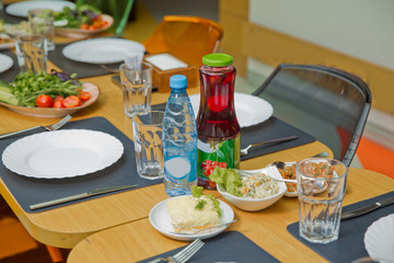 Plate fork, knife, glass. Kampot drink. Tomato cucumber and steak salad. A children's table in the restaurant.