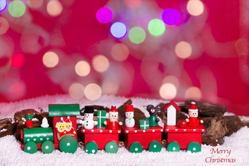 trenecito de navidad en fo ando rojo y nevado, con luces en bokeh . Merry christmas y sin letrero