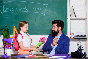 Back to school. Best wishes. Knowledge day congratulations. Greetings for school pedagogue. School holiday. Thankful schoolgirl. Girl adorable pupil with backpack giving bouquet flowers teacher
