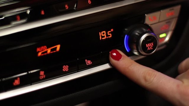 girl turns on seat heating in a car