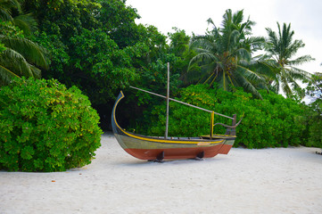 Wooden boan on the tropical seashore with white sand