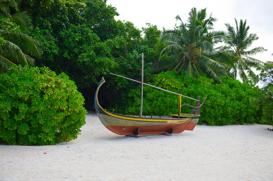 Wooden boan on the tropical seashore with white sand