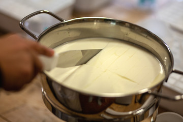 Käse selber machen: die in einem Topf eingedickte Milch wird zerschnitten