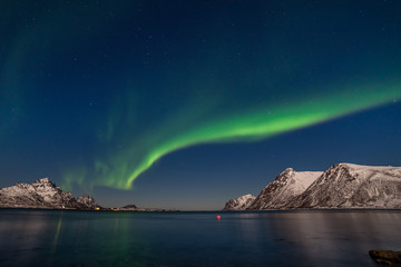 Naklejka na ściany i meble beautiful aurora borealis, polar lights, over mountains in the North of Europe - Lofoten islands, Norway