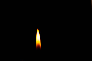 Close-up fire lighter on a black background, candle flame set isolated in black background