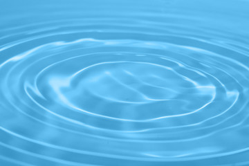 Closeup Water drop falling on the surface of the water and beautiful circular wave ripple, fresh natural mineral water drink water concept