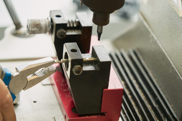 Key duplication machine operated by a locksmith in the process of duplicating a key