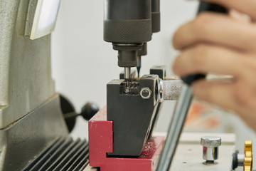 Key duplication machine operated by a locksmith in the process of duplicating a key