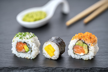 Japanese food sushi rolls uramaki and vasabi in reflection.