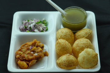 Indian Snacks Golgappa Pani Puri Poori in White Plate and Black Background