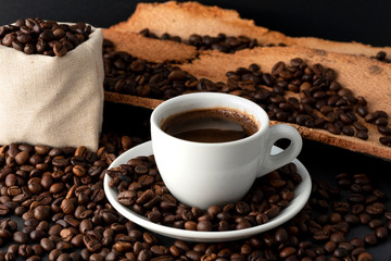 Cup of Coffee and Coffee Beans on Black Background, close-up