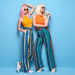 Two fashionable girl posing in Studio. Beautiful Adorable young woman in Stylish summer colorful...